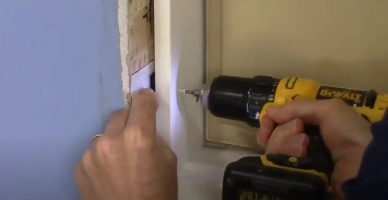 Vidcap of screwing pet door to rough opening